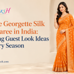 Woman wearing an orange georgette silk print saree as a wedding guest look